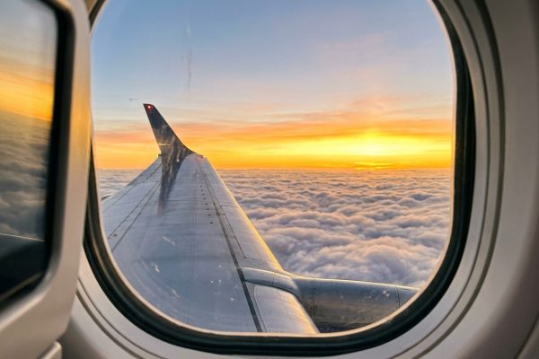 Vista del ala de un avión sobre las nubes al amanecer